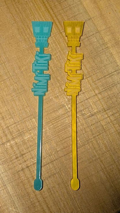 Two plastic stir sticks, one blue and one yellow, on a wooden surface.