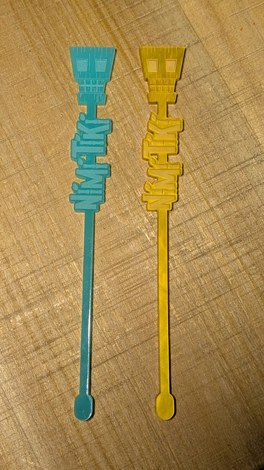 Two plastic stir sticks, one blue and one yellow, on a wooden surface.